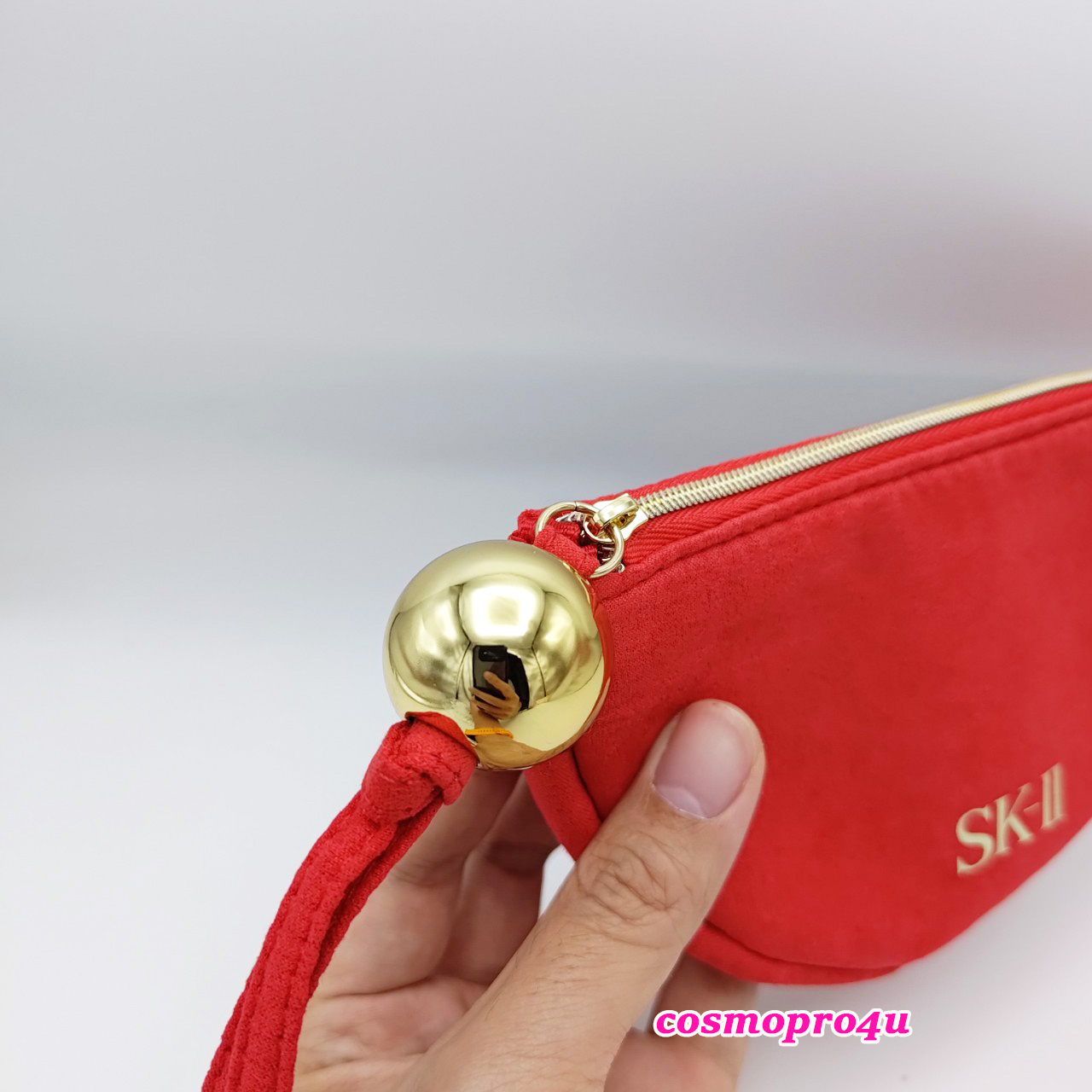 กระเป๋า เครื่องสำอาง SK-II สีแดง ทรงครึ่งวงกลม มีลูกบอลสีทองที่ห่วงซิป ขนาด 18x10cm