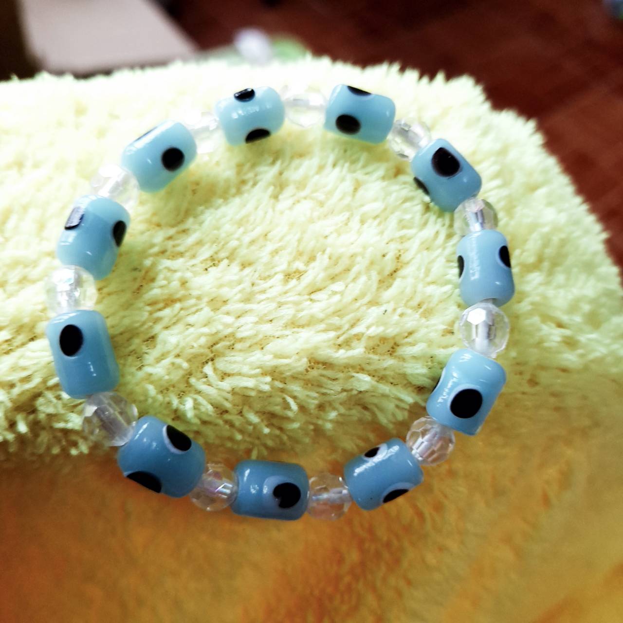 สร้อยข้อมือ ลูกปัดเซรามิคอีวิลอายสีฟ้าอ่อนสลับลูกปัดอะครีลิคเหลี่ยมเจียใส6มิล ยืดได้ จำนวน 1 เส้น